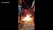 Man pours kerosene on line of fire before walking barefoot over it