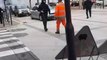 Un policier met un coup de casque à un homme en pleine rue.