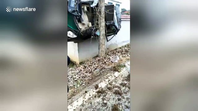 Car crashes off-road and gets wedged between a tree and a wall