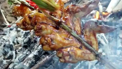 The young man cooks chicken wings deliciously in the wild.