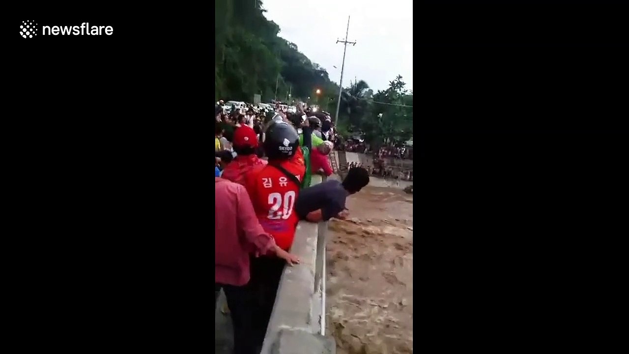 Dramatic moment mother and three children are rescued from raging river in Philippines