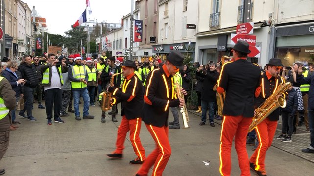 Les Gilets jaunes dansent avec la fanfare de Noël dans le centre-ville