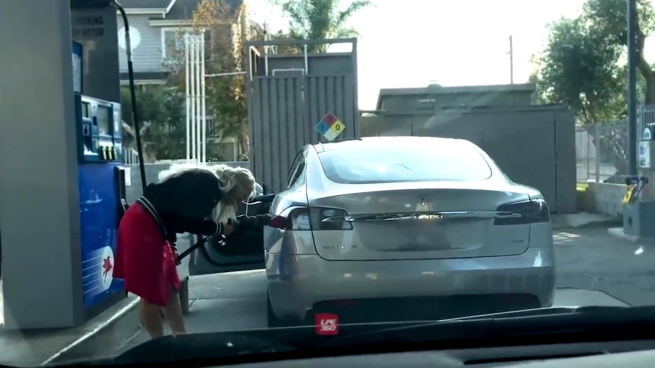 Une blonde essaye de faire le plein de sa Tesla dans une station-service