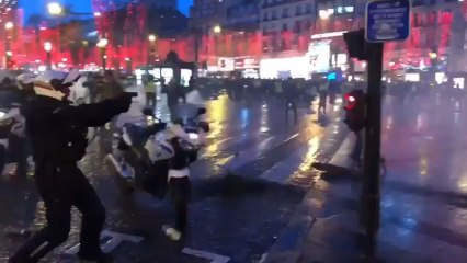 Un policía apunta con su pistola a los 'chalecos amarillos'