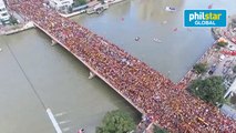 Thousands of Catholic devotees swarm towards the Black Nazarene as it passes the Jones Bridge in Manila