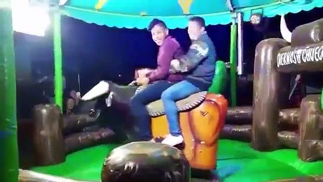Deux jeunes hommes font du rodéo sur un taureau mécanique et vont faire rire tout le monde !