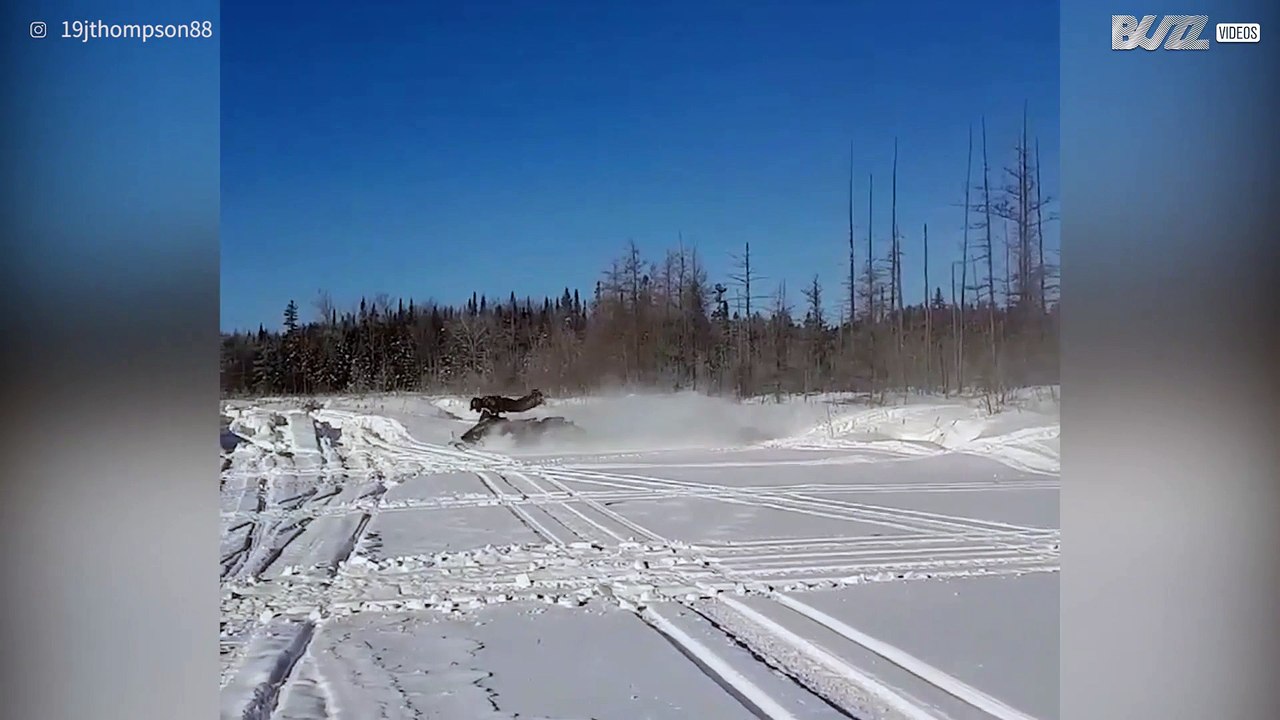 Snowmobile driver makes risky front flip while...