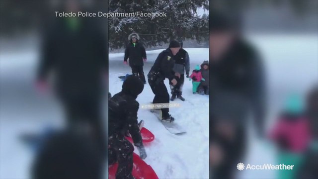 Police officer takes some sledding lessons