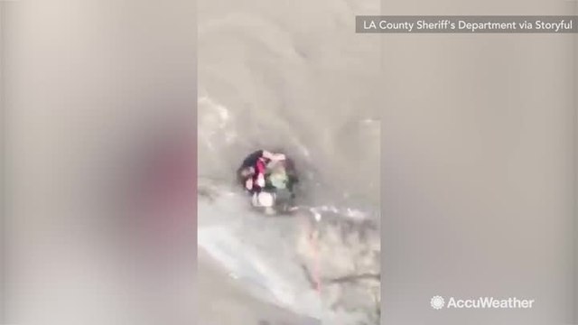 Helicopter crew rescues woman caught in flooded river