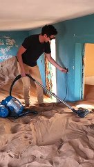 Il passe l'aspirateur.. dans une maison remplie de sable !