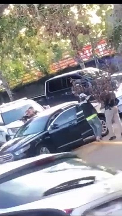 Une fillette de 2 ans sort d'une voiture les mains en l'air lors de l'arrestation de ses parents