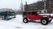 Un bus remorqué par trois SUV à cause de la neige à Montreal