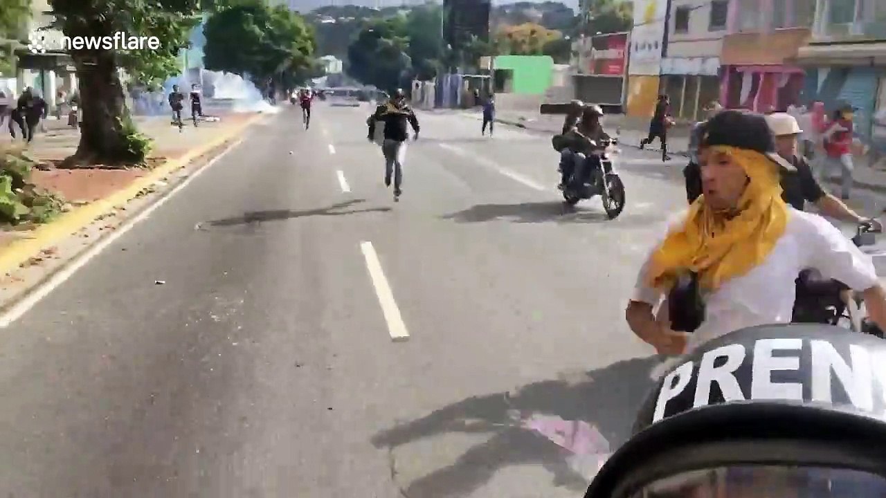 'They are chasing us!' Venezuelan journalist films moment he fled riot police on motorbike