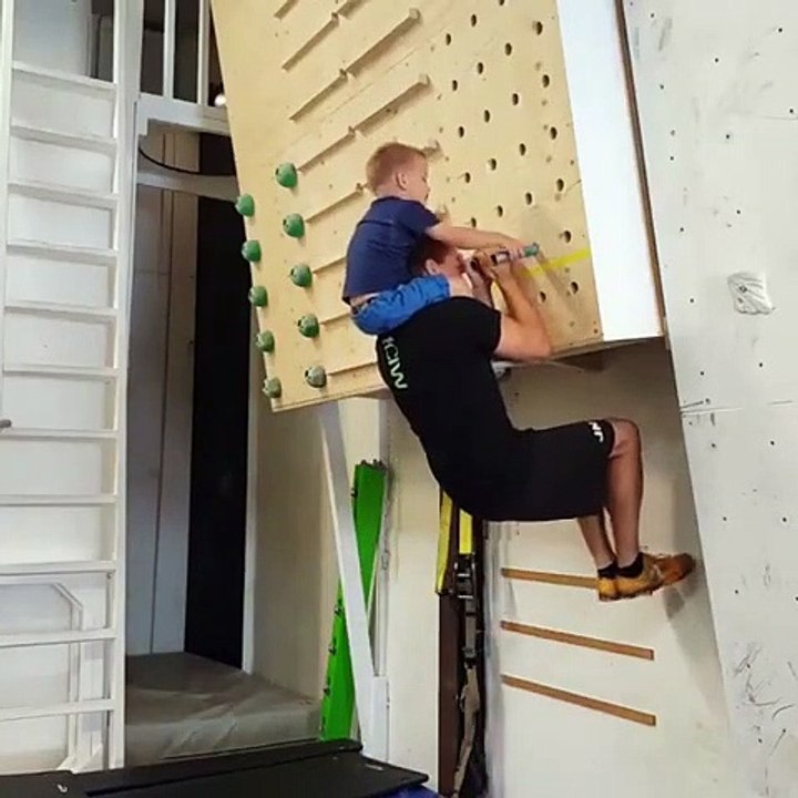 Il fait ses tractions avec son fils sur les épaules !