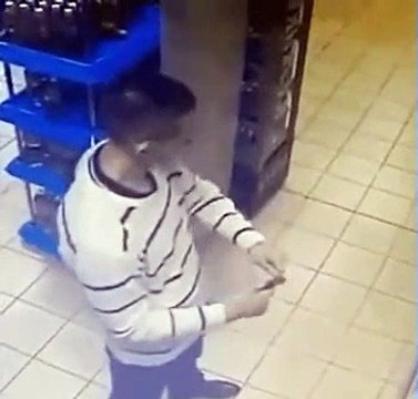 Un homme boit une bouteille de Vodka dans le magasin pour éviter de payer son prix