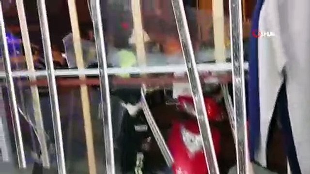 Motosikletli pizza kuryesi giysi mağazasının camından içeri girdi