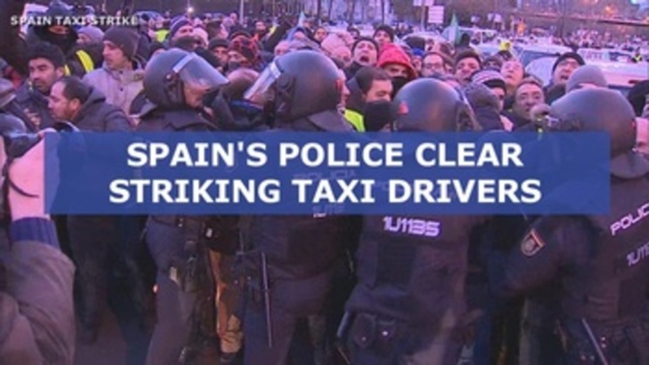 Spain's riot police move in to clear striking taxi drivers blocking Madrid