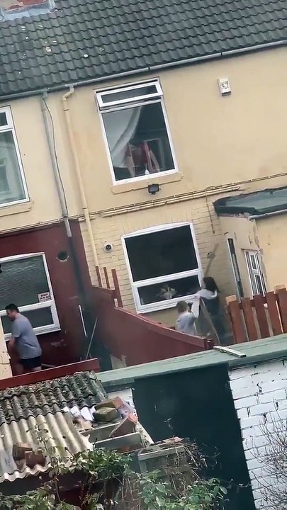 Des voisins se balancent des planches par dessus la clôture pendant lors d'une altercation