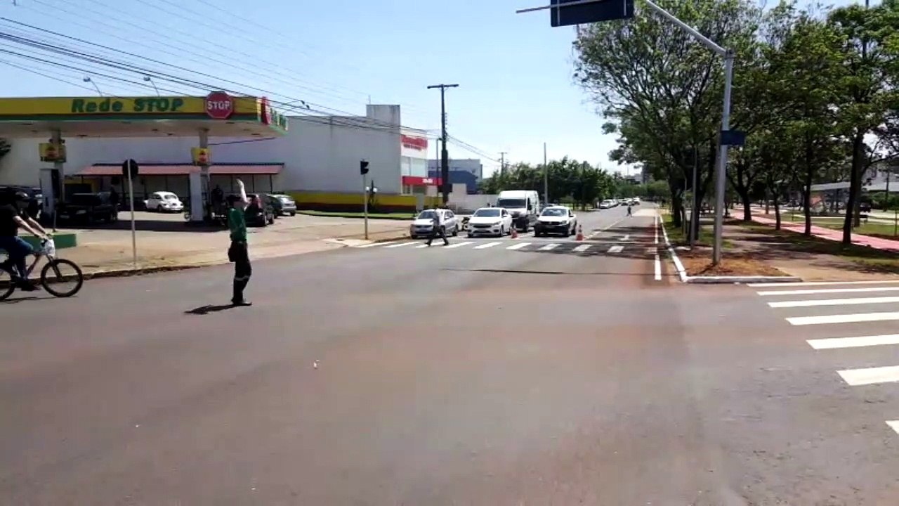 Agentes orientam trânsito em semáforo na Avenida Tancredo Neves