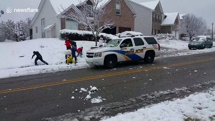 Friendly police join in snowball fight with neighbourhood kids
