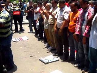 المتظاهرين يؤدون الصلاة أمام الدستورية.