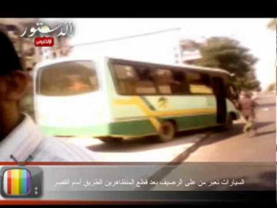 السيارات تعبر من على الرصيف بعد قطع المتظاهرين الطريق أمام القصر