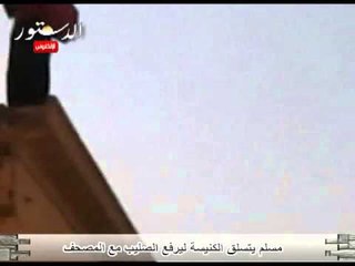 مسلم يتسلق الكنيسة ليرفع الصليب مع المصحف