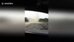 Terrified driver watches as dust devil approaches his car