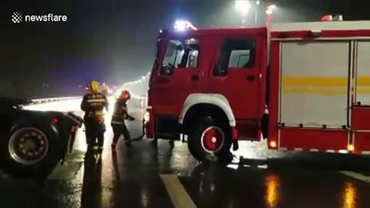 Firefighters use crane to save truck driver in trailer hanging off edge of a bridge