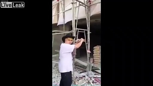Il se prend une brique sur la tête en secouant l'échafaudage