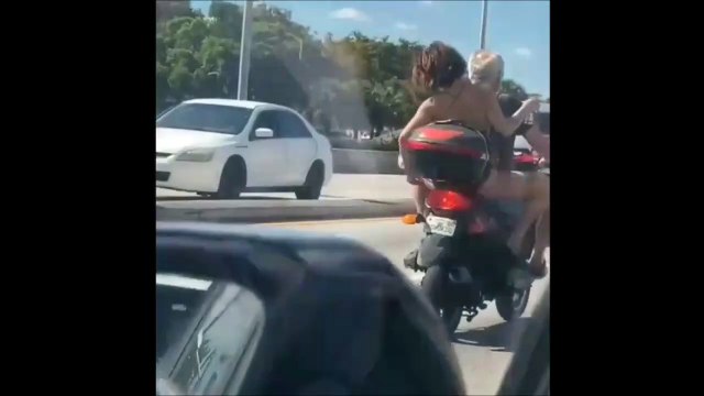 Une femme qui se rase les jambes sur une moto... Normal