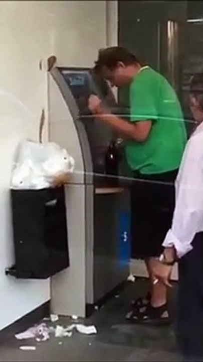 Cet homme ivre est trop bourré tente de retirer de l'argent au distributeur !