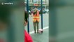 Old Chinese woman suspends her head from horizontal bar to work out