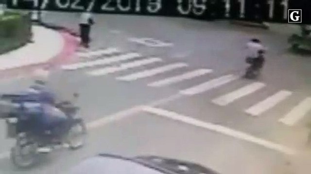 Dois homens em uma moto tentam atirar em outro homem a pé.jpg