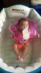 Este bebé duerme en su baño mientras toma su biberón