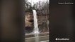 There's so much flooding, this waterfall forms on side of highway