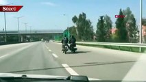 Arkadaşının motosikletine ayağıyla tutunarak yolculuk yaptı
