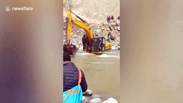 Local people transported by JCB across river to escape landslide in north India