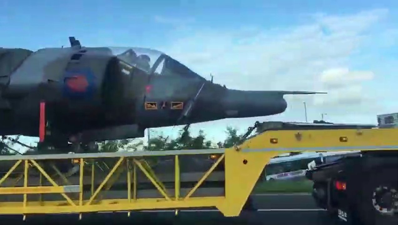 Il y a un pilote dans le cockpit de l'avion transporté sur ce camion !