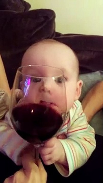 Bébé déjà accro au vin ? Il essaye de le boire à travers le verre lol