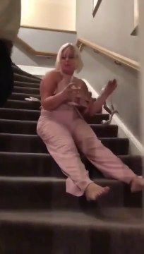 Tellement ivre qu'elle descend les marches assise !