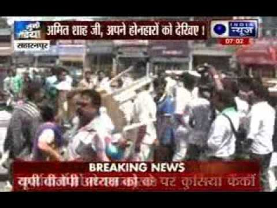 BJP activists throwing chairs at each other, shown black flags