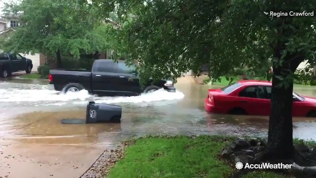 Vehicles dangerously navigate through flooded streets