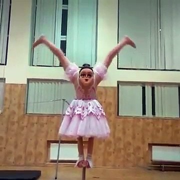 Une fille fait de la danse acrobatique avec un masque sur les fesses