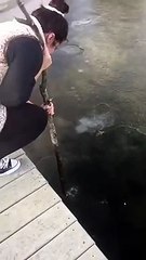 Une fille essaie de briser la glace avec un bâton