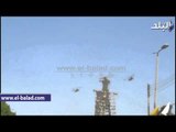 طائرات الهليكوبتر تحلق فى سماء الفيوم وتلقى أعلام مصر على المواطنيين