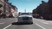 White luxury Rolls Royce driving on city street in summer day