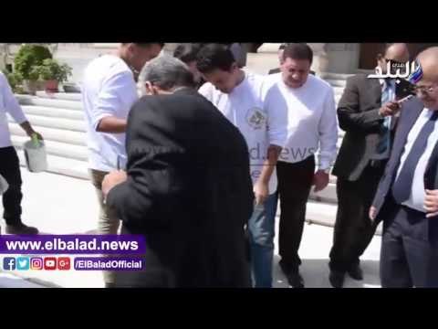 صدى البلد | جابر نصار يشارك طلاب جامعة القاهرة في دهان أحد الأرصفة.