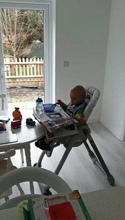 Comme un grand, ce bébé lit le journal pendant le petit-déjeuner