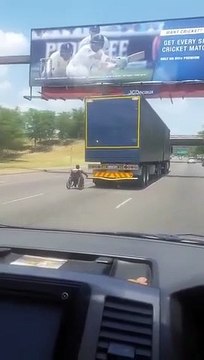 Hombre en silla de ruedas se agarra a camión en autopista